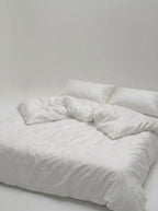 Bloom duvet cover set made up on a double bed, the woven floral pattern raised across the surface