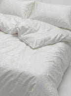 Close view of the Bloom pattern across the duvet and pillowcase, tone on tone in white